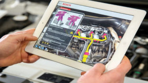BOSCH AR Used For Business Employee Training, close up of i-pad held over some motor parts with AR information displaying on screen