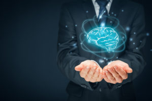 Man holding a the illustration of a brain in his hands with electrons circling around the brain