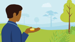 A person holding a coin in a garden