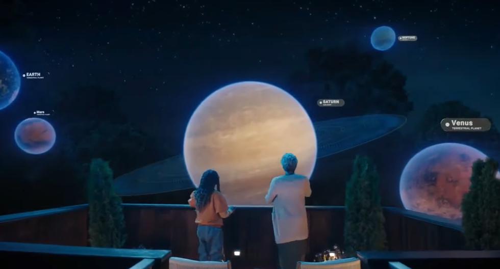 two people standing on a balcony looking at planets