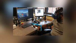 Man tests VR headset and Haptic Feedback Gloves at the work desk