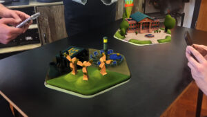 AR climate change game with 3D models of different energy sources and a town hall on a real table