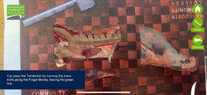 A still from out AR butchery app showing the tenderloin being cut around by the bone knife, with the instructions on screen, and buttons for Home, Bones and Primaries on the right