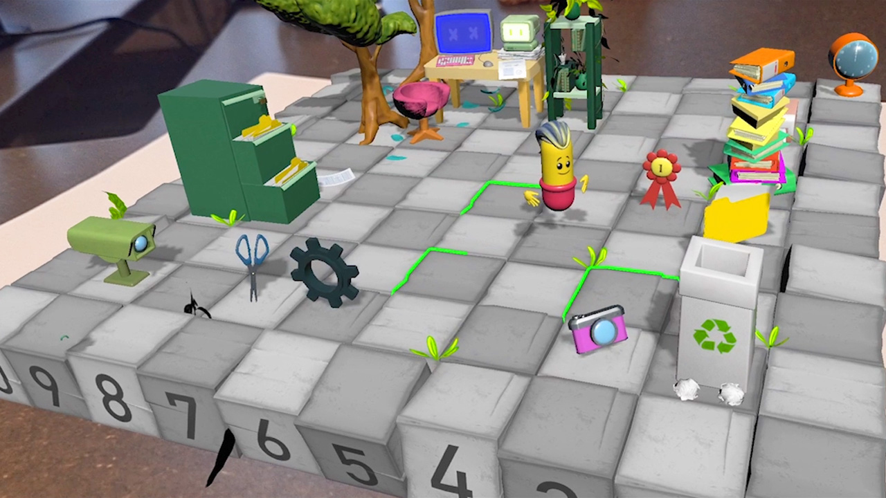 Augmented reality game preview featuring animated objects on a numbered grid floor. A cartoon character is walking on a checkered board. Surrounding elements include a file cabinet with folders, a pair of scissors, a gear, a plant, a computer desk with a pink chair, a stack of books with a ribbon, a globe, and a recycling bin with crumpled paper balls.