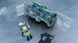 Two engineers in high-visibility jackets and helmets use a tablet to interact with an augmented reality (AR) display of a large turbine engine, showing system diagnostics, maintenance training, and performance data.