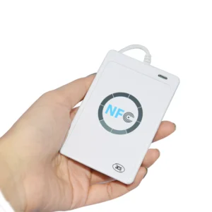 A hand holding a white NFC card reader (ACS ACR122U) with a circular NFC logo and a connected cable.