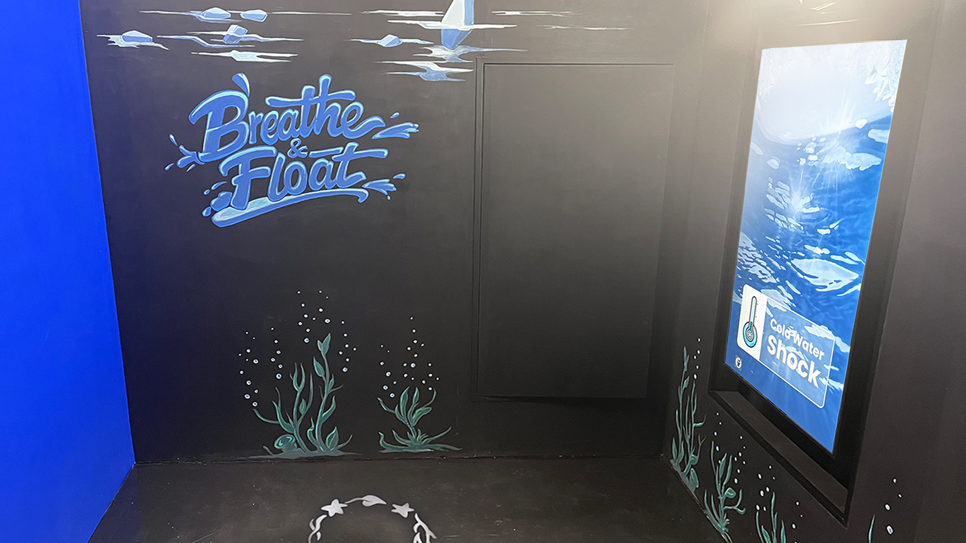 Immersive water safety room with “Breathe & Float” wall art and interactive cold water shock display